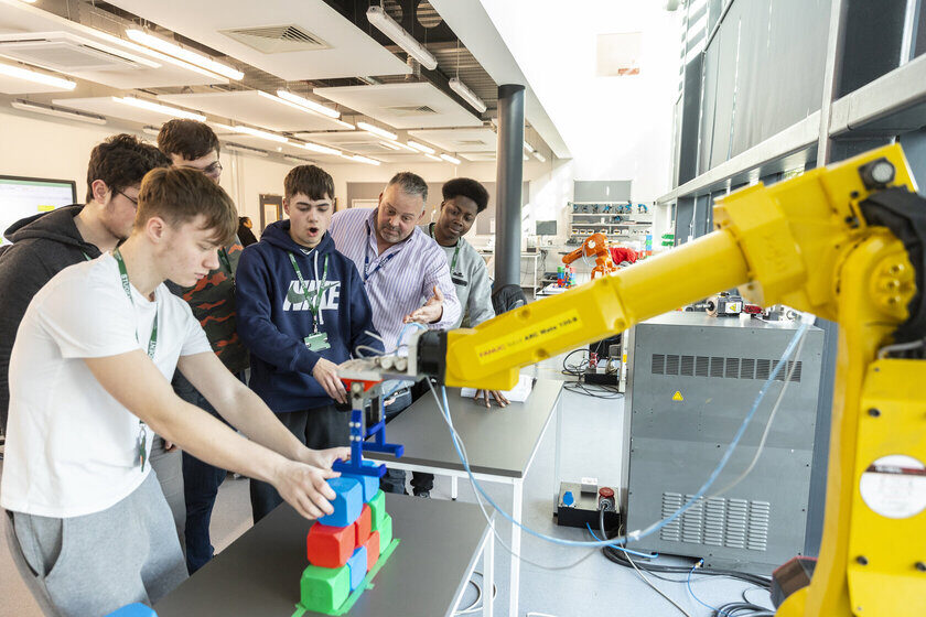 Engineering students and tutor with robotic arm Bedford College