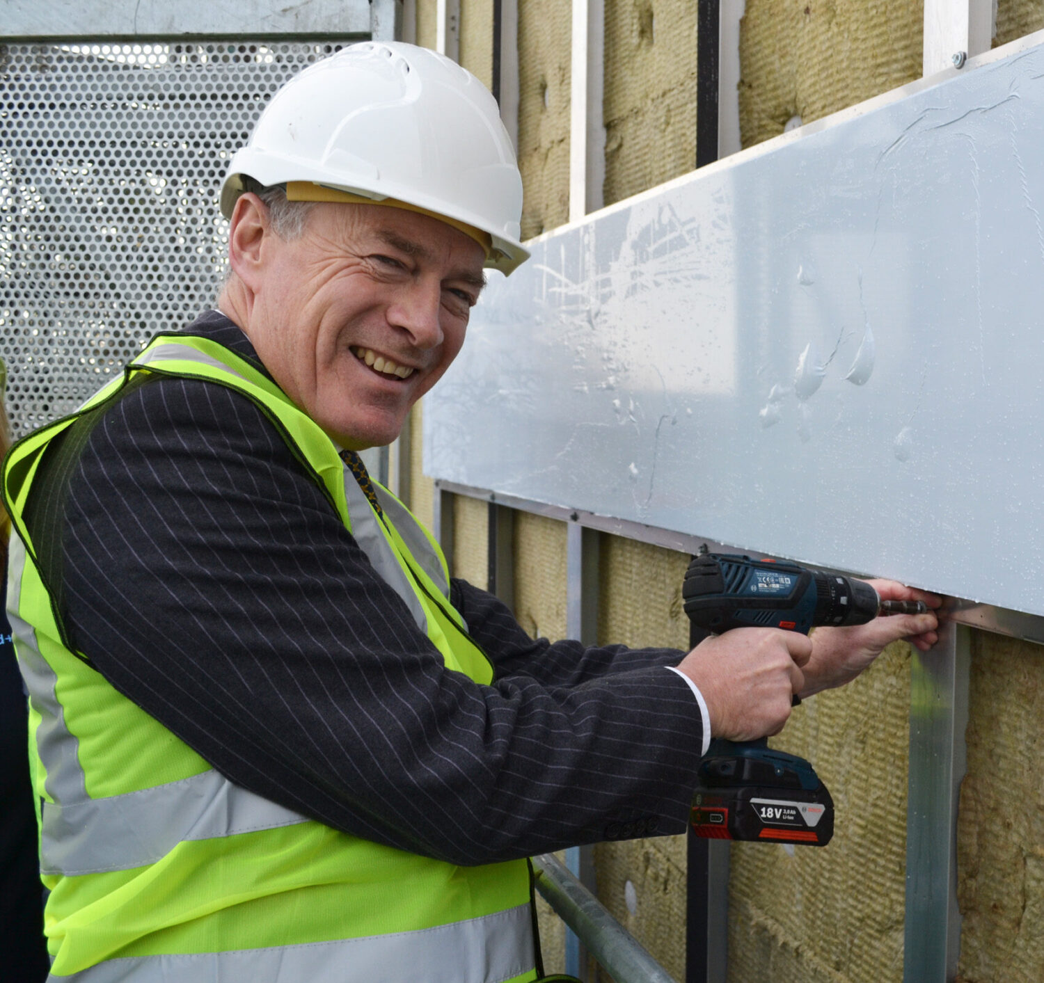 Ian Pryce putting on first cladding pannel at Wellingborough