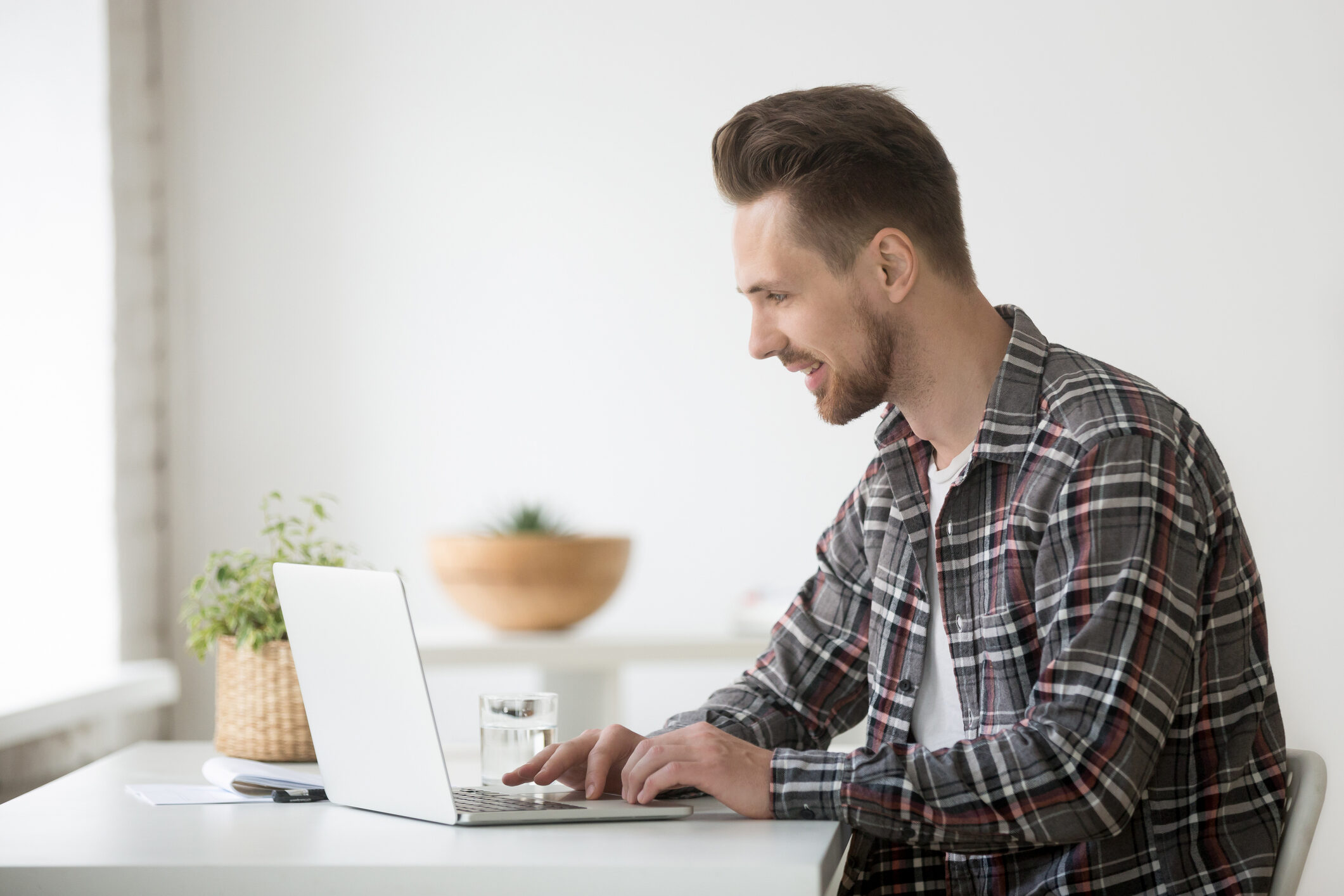 Smiling man freelancer working on laptop communicating online using software